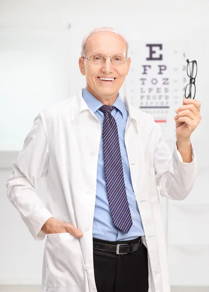 Mature optician holding glasses — Stock Photo, Image