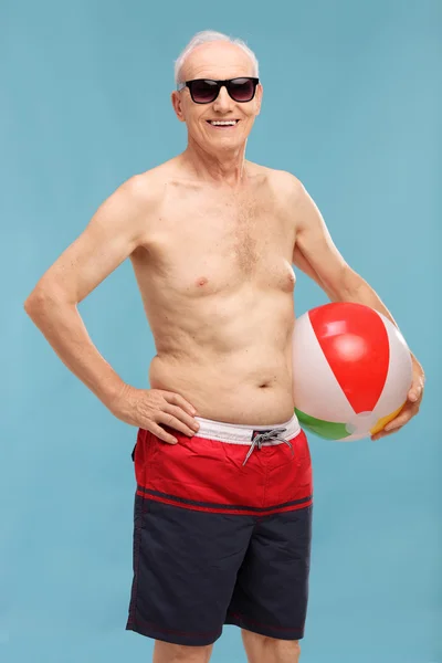 Senior man holding a beach ball — Stock Photo, Image