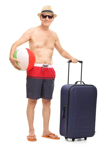 Senior man holding  beach ball and a bag — Stock Photo, Image