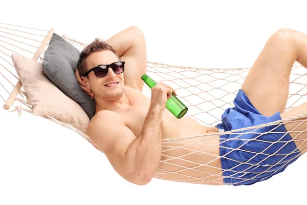 Man liggend in een hangmat en drinken van een biertje — Stockfoto