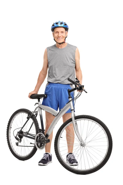 Senior biker standing behind a bicycle — Stock Photo, Image