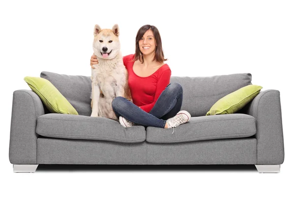 Gadis dengan anjingnya duduk di sofa — Stok Foto