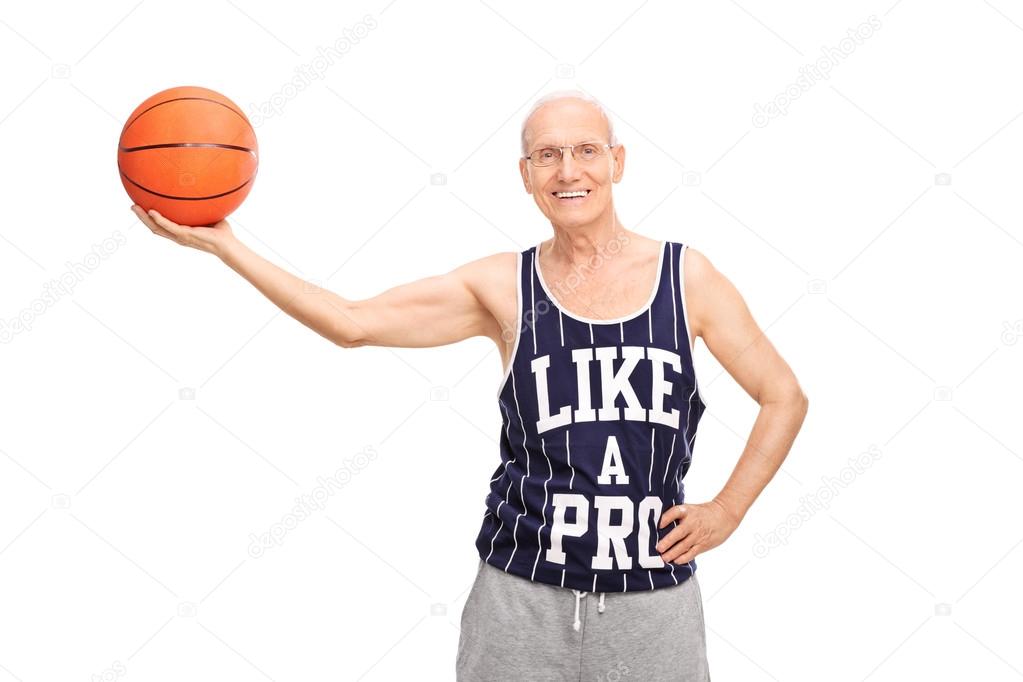 Cheerful senior man holding a basketball 