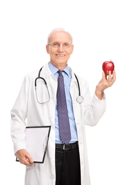 Medico maturo con mela rossa in mano — Foto Stock