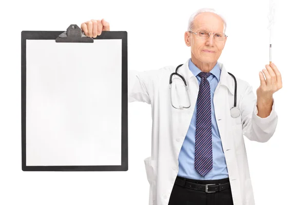 Mature doctor holding cigarette and a clipboard — Stock Photo, Image