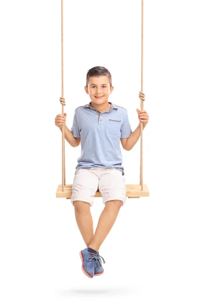 Joyful little boy sitting on a swing — Stock Photo, Image