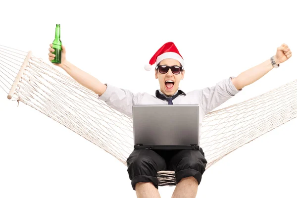 Cara com chapéu de Santa trabalhando em um laptop — Fotografia de Stock