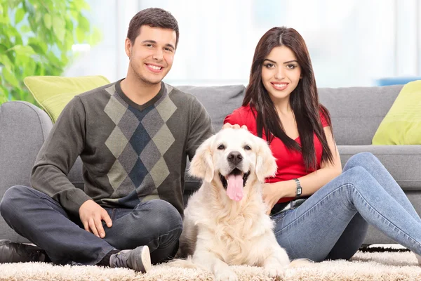 Jeune couple assis avec un chien — Photo