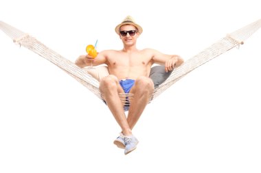 Carefree guy in hammock drinking a cocktail