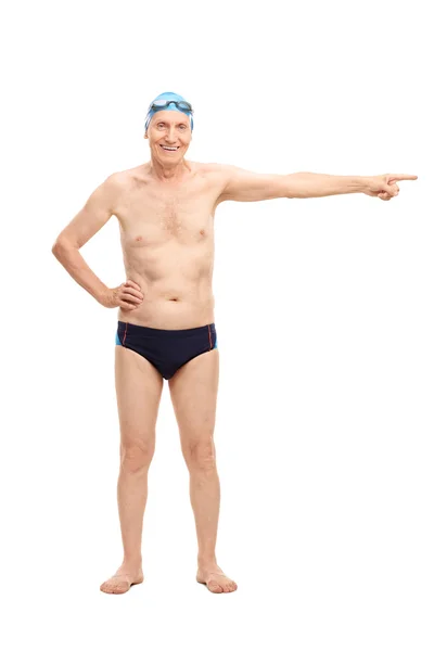Senior man in swim trunks pointing with hand — Stockfoto