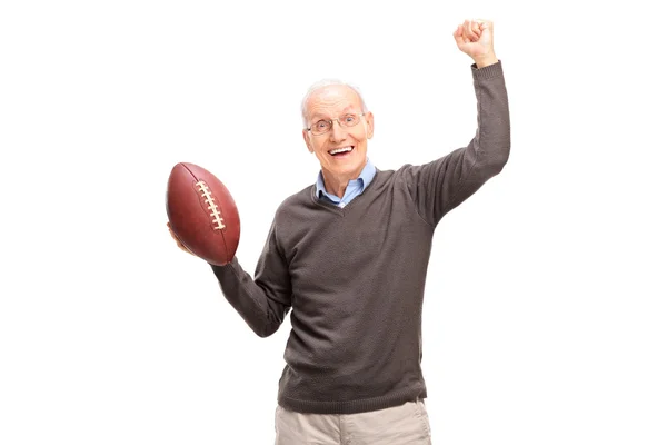 Senior man holding an American football — Stok fotoğraf