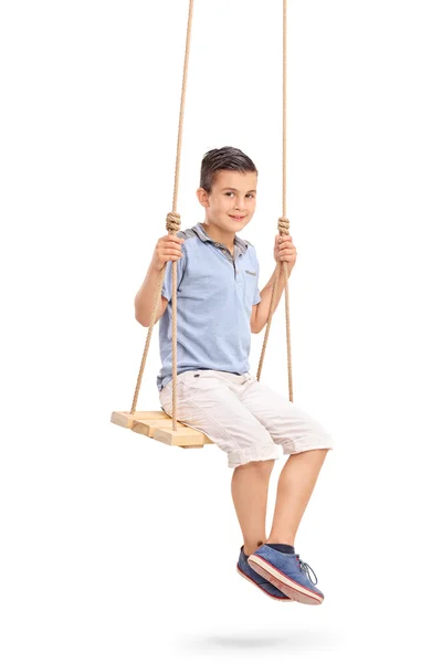 Joyful little kid sitting on a swing — Stock Photo, Image