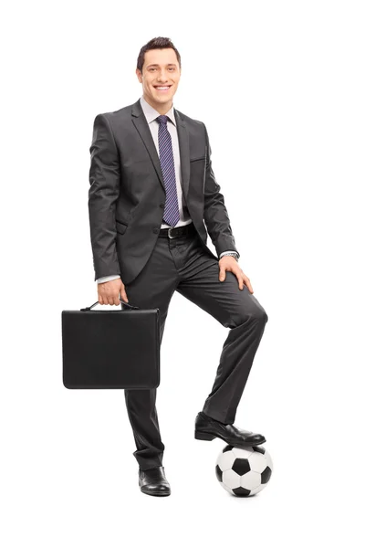 Businessman posing with a football — Stockfoto