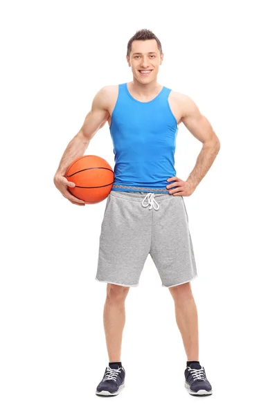 Joven atleta masculino sosteniendo una pelota de baloncesto — Foto de Stock