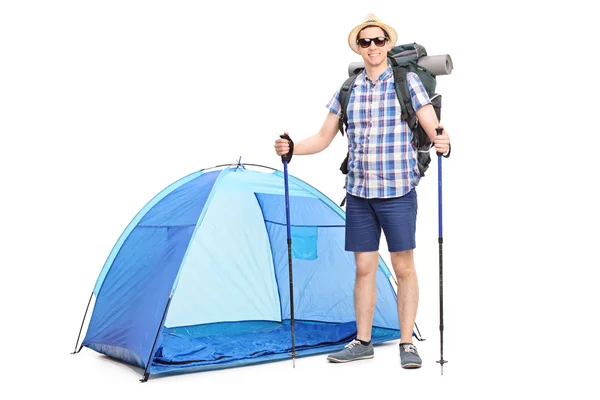 Jovem caminhante posando na frente de uma tenda azul — Fotografia de Stock