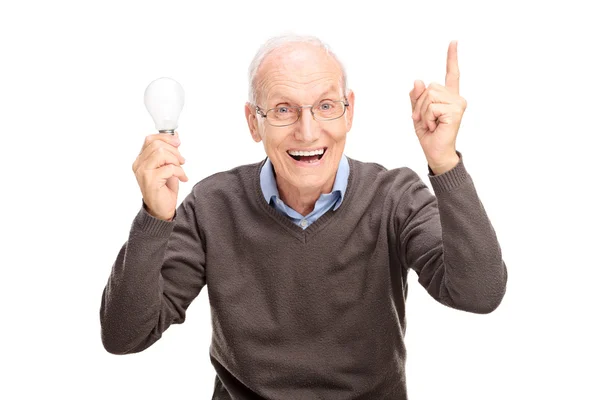 Senior sosteniendo una bombilla y haciendo un gesto con la mano — Foto de Stock