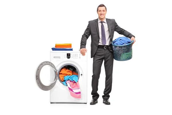 Young businessman holding a laundry basket — Stock fotografie