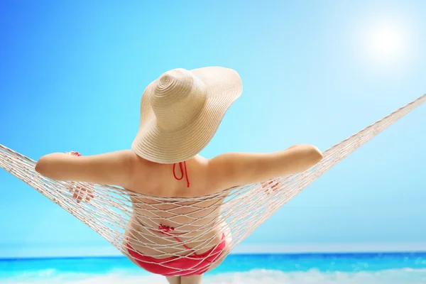 Donna con un cappello elegante sdraiata su un'amaca — Foto Stock