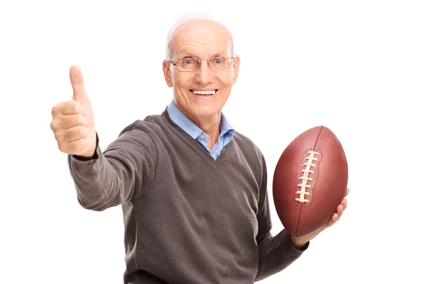 Senior holding a football and giving thumb up — Stock Photo, Image