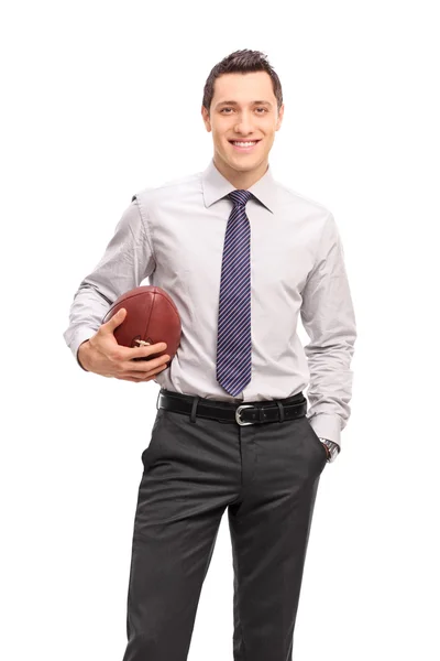 Vertical shot of a young businessman holding a football — Stock Photo, Image