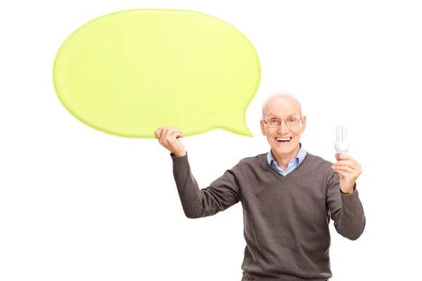 Senior sosteniendo una bombilla y una burbuja de habla —  Fotos de Stock