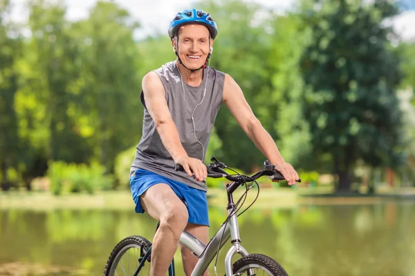 Vélo senior avec un casque bleu posant sur son vélo — Photo