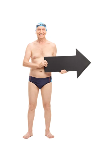 Senior man in a swim trunks holding an arrow — Stock Photo, Image