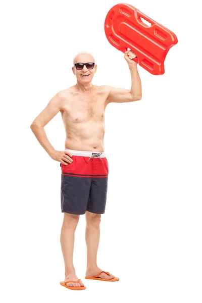 Senior holding a swimming float up in the air — Stockfoto