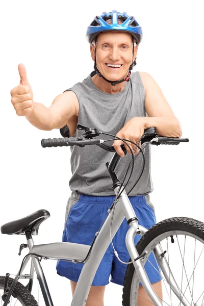 Senior posando detrás de la bicicleta y dando un pulgar hacia arriba — Foto de Stock