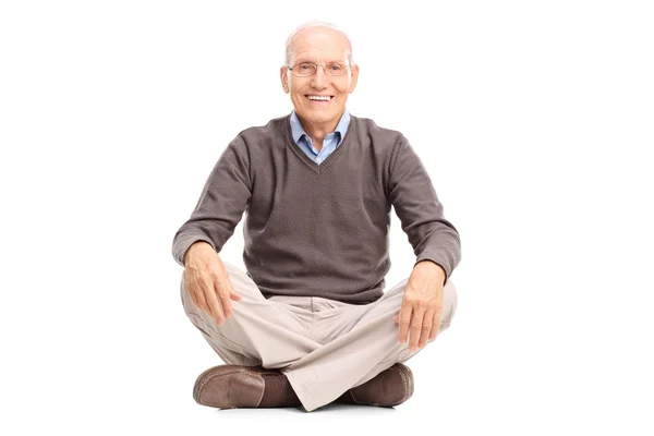 Fröhliche Seniorin auf dem Boden sitzend — Stockfoto