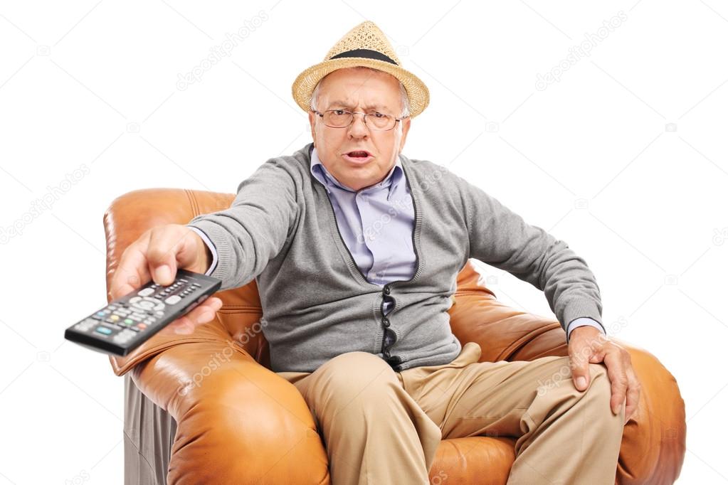 senior man pressing buttons on a remote control