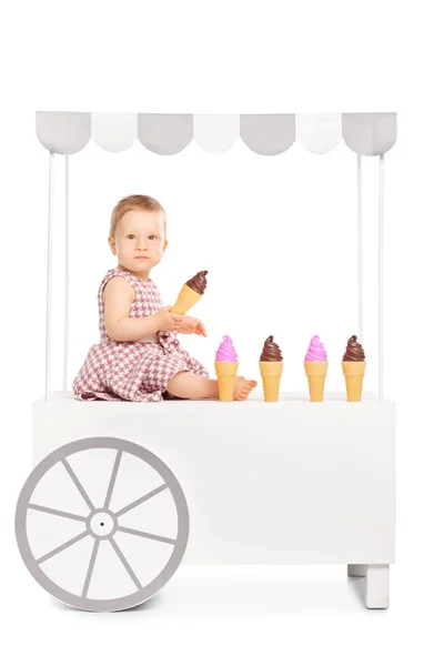 Baby girl on ice cream stand — 图库照片