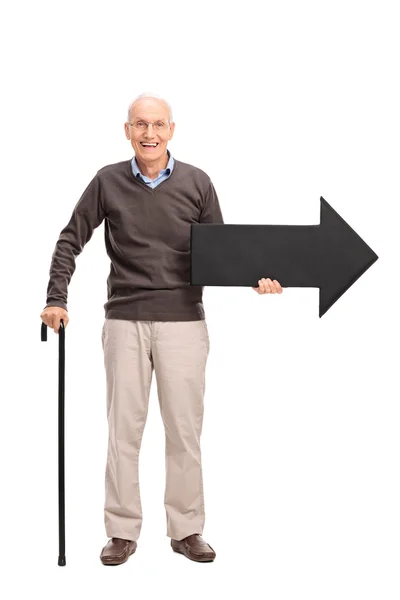 矢印を保持している杖を持った年配の男性 — ストック写真