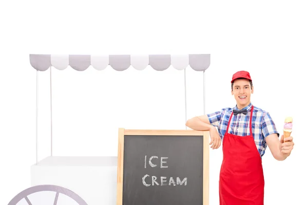 Junge männliche Verkäuferin steht an einem Eisstand — Stockfoto