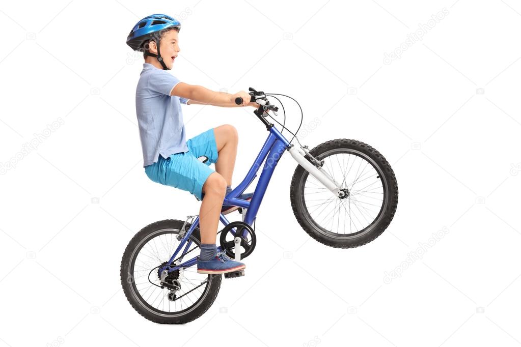 Little boy doing a wheelie on a bike