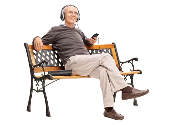 Senior man listening to music on cell phone — Stok fotoğraf