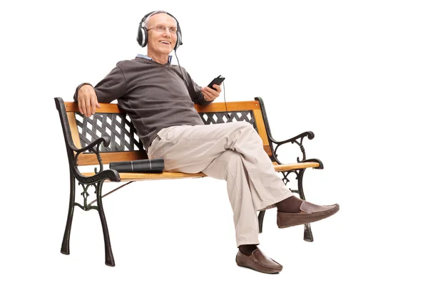 Senior man listening to music on cell phone — 图库照片