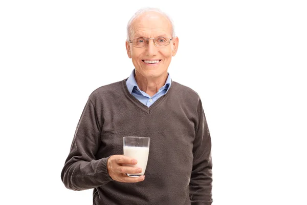 Senior gentleman holding a glass of milk — Zdjęcie stockowe