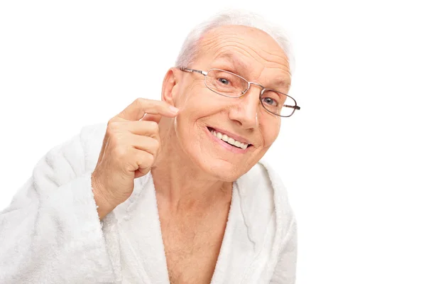 Пожилой человек проверяет свою кожу — стоковое фото