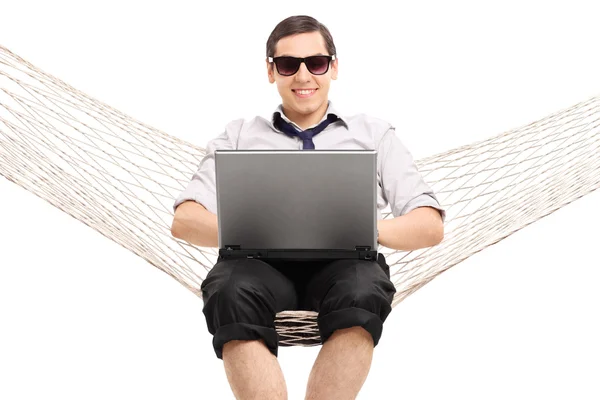 Biznesmen siedzi na hamaku i pracy na laptopie — Zdjęcie stockowe