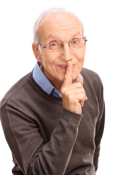 Старший джентльмен держит палец на губах — стоковое фото