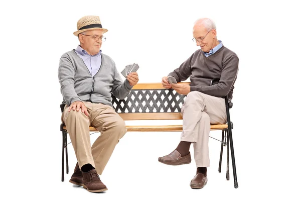 Μεγαλύτερης ηλικίας άνδρες παίζουν χαρτιά σε ένα παγκάκι — Φωτογραφία Αρχείου