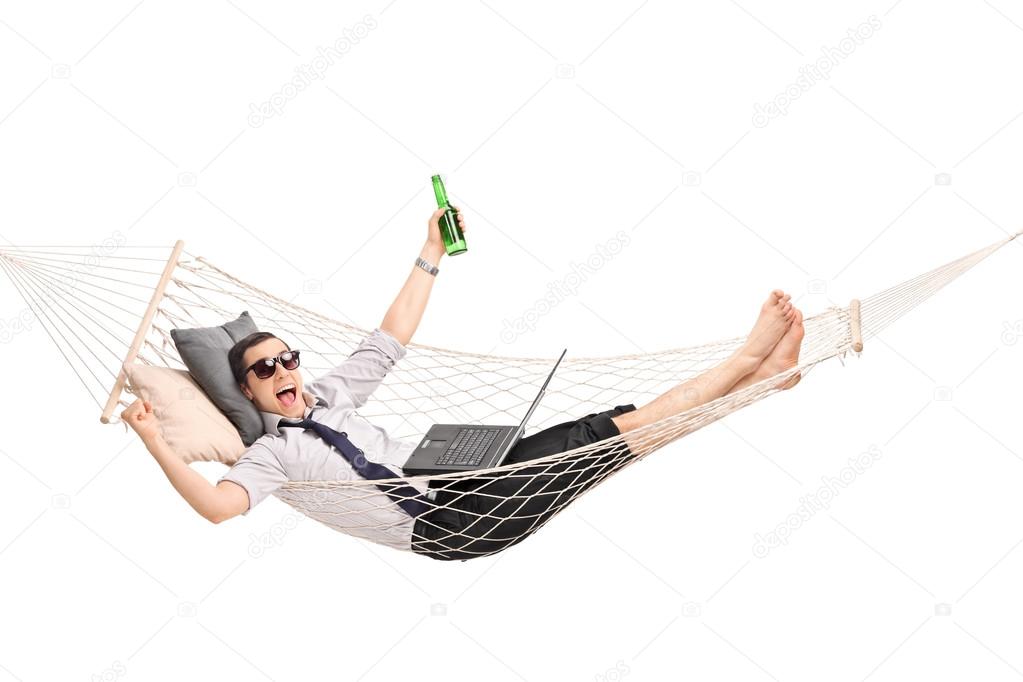 Businessman in hammock working on a laptop