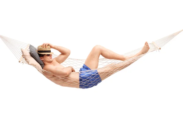 Jovem sem camisa deitado em uma rede — Fotografia de Stock