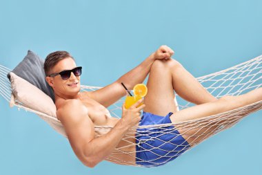 hamakta yalan ve bir kokteyl tutan adam