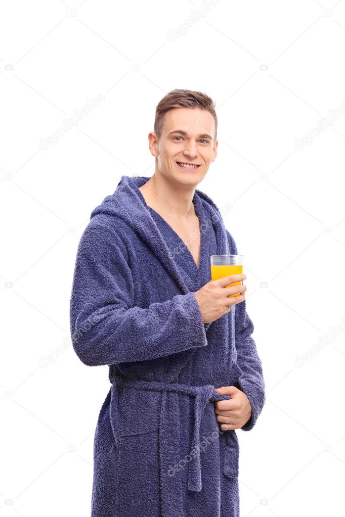 young man in bathrobe holding a juice