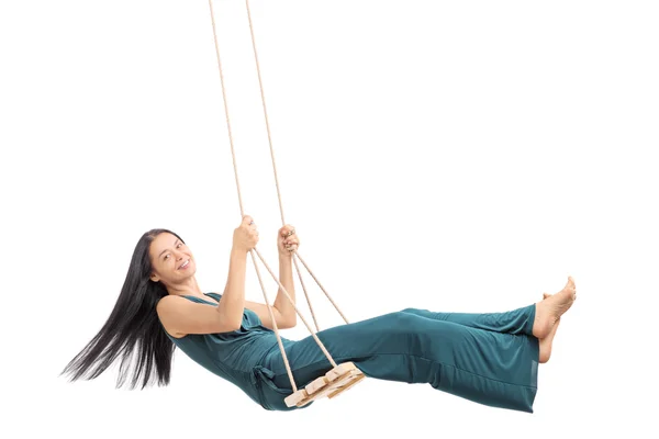 Fashionable woman swinging on a wooden swing — Stock Photo, Image