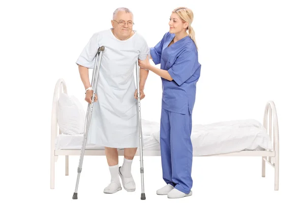 Kvinnliga sjuksköterskan att hjälpa en äldre patient — Stockfoto