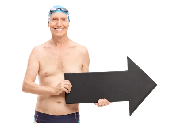 Senior man in a swim trunks holding arrow — Stock Photo, Image