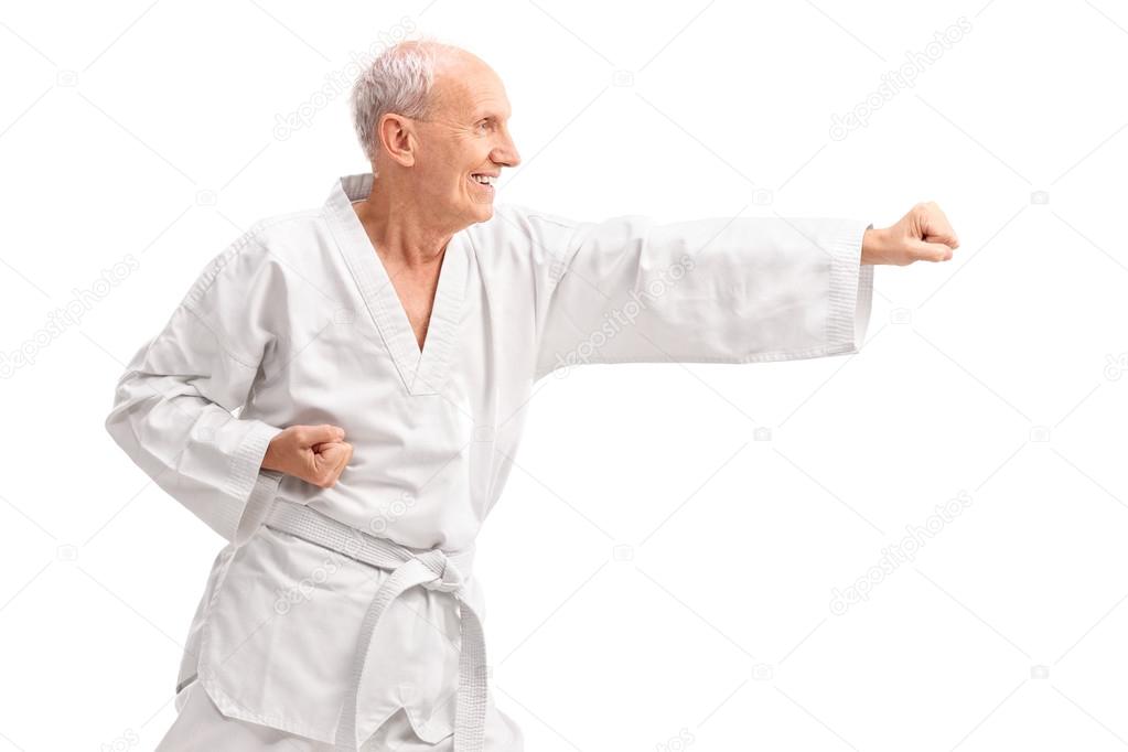 Old man in kimono practicing karate